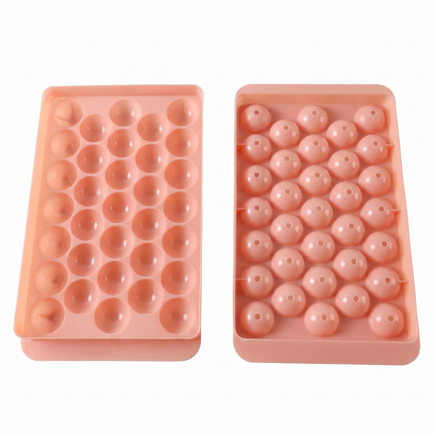 Two pink plastic ice ball trays, one with open spherical molds and the other with covered molds.