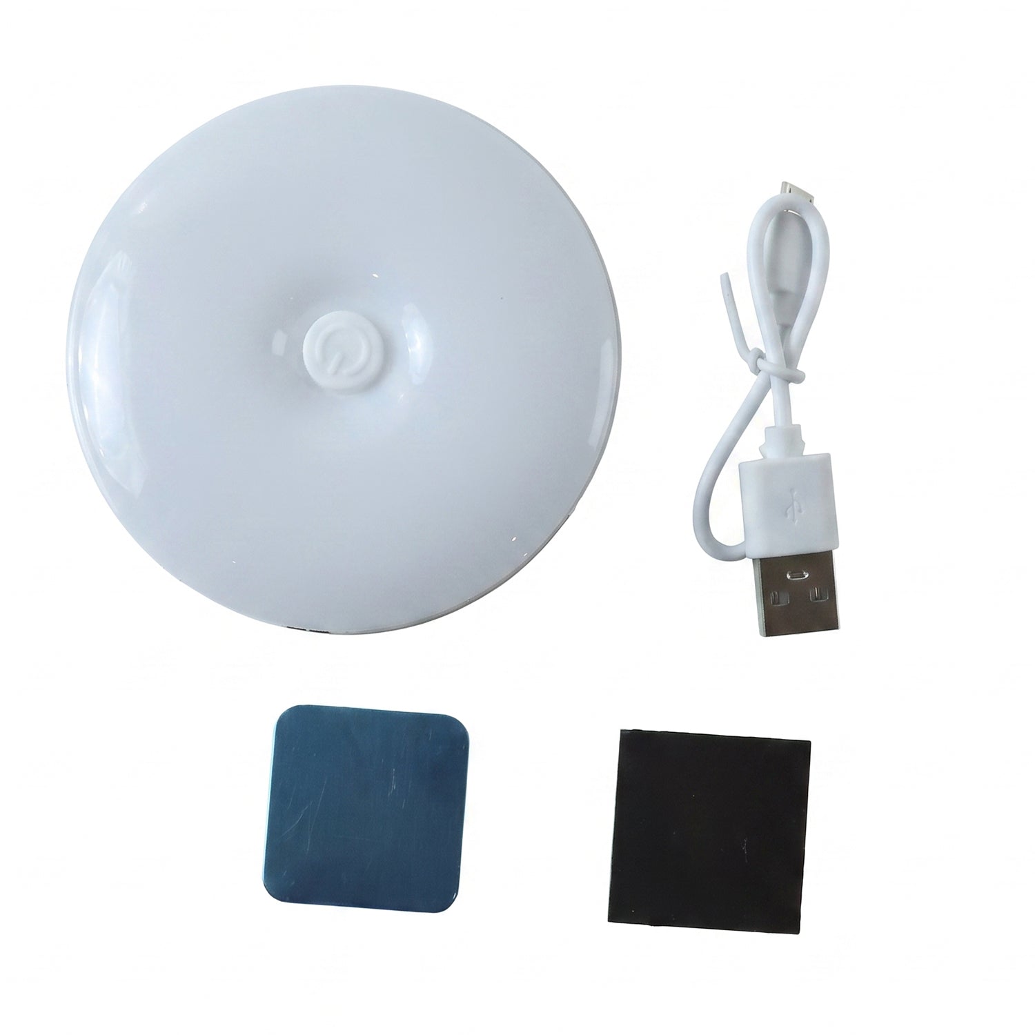 A white, round LED light, a white USB charging cable, a blue adhesive pad, and a black magnetic pad on a white background.