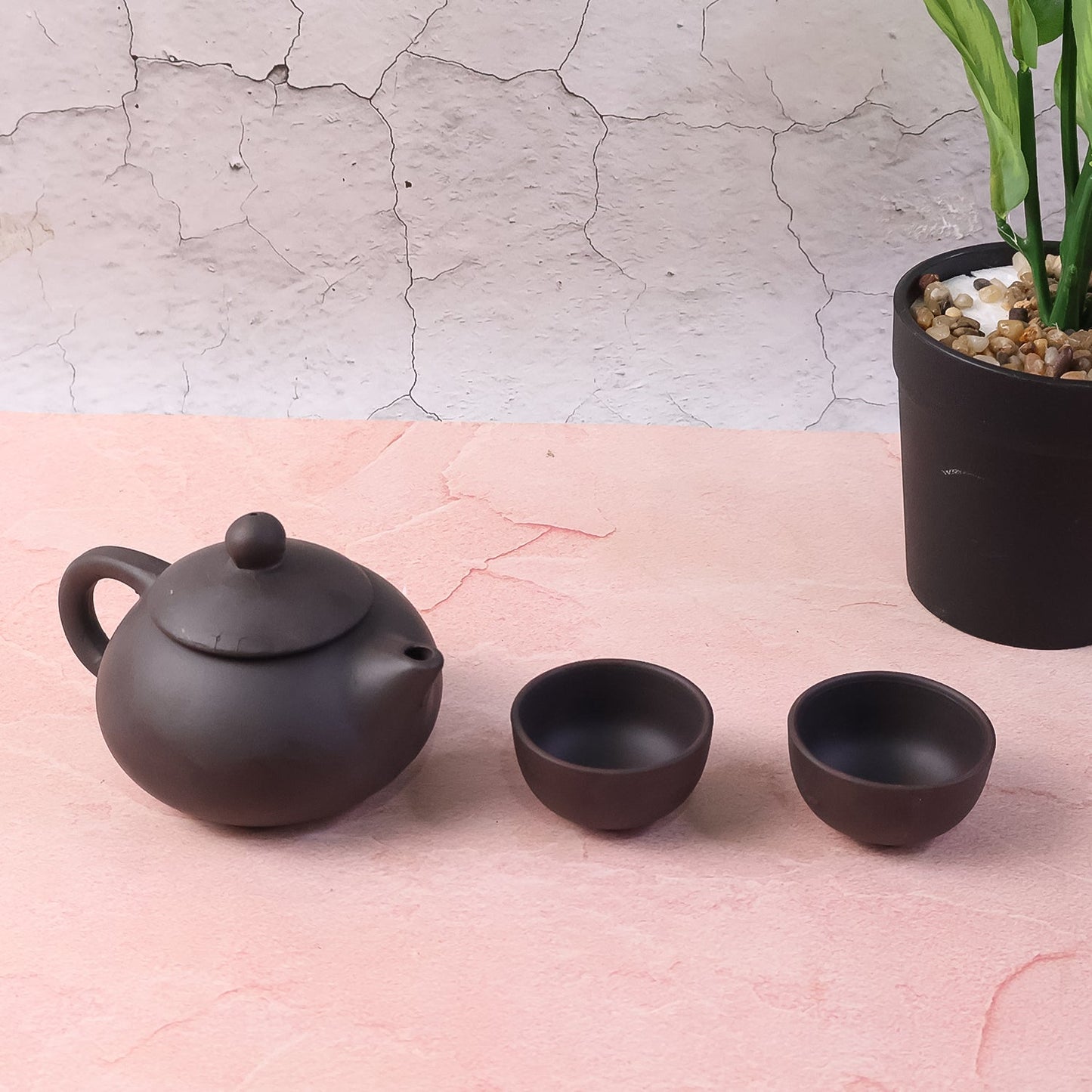 Side view of matte black ceramic tea set with teapot and cups