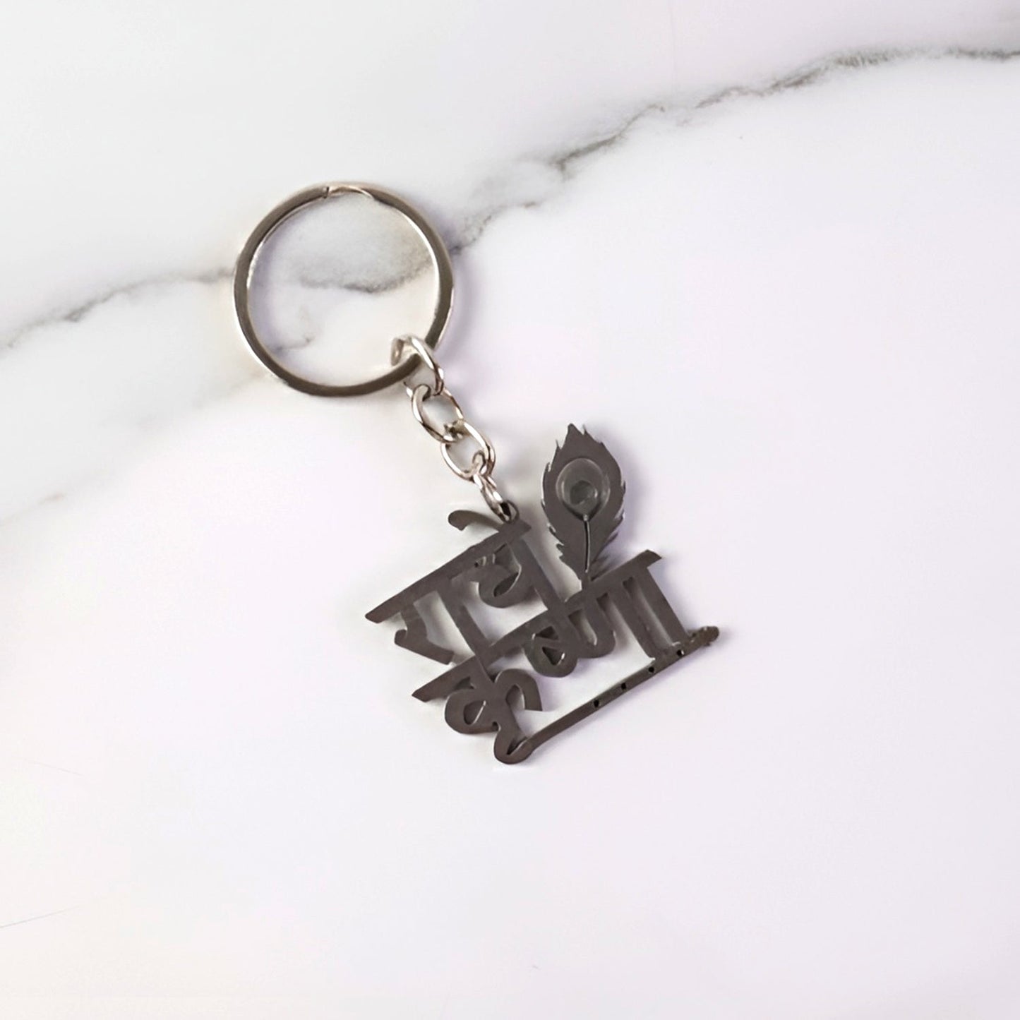 Key pendant attached to Radhe Krishna metal keychain highlighting craftsmanship