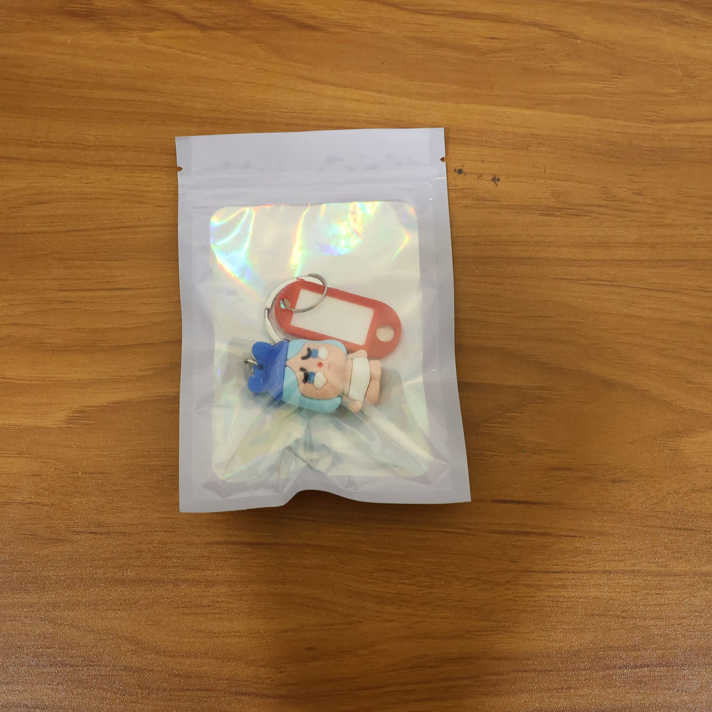 Lifestyle image of cartoon baby character keychain used on backpack zipper.