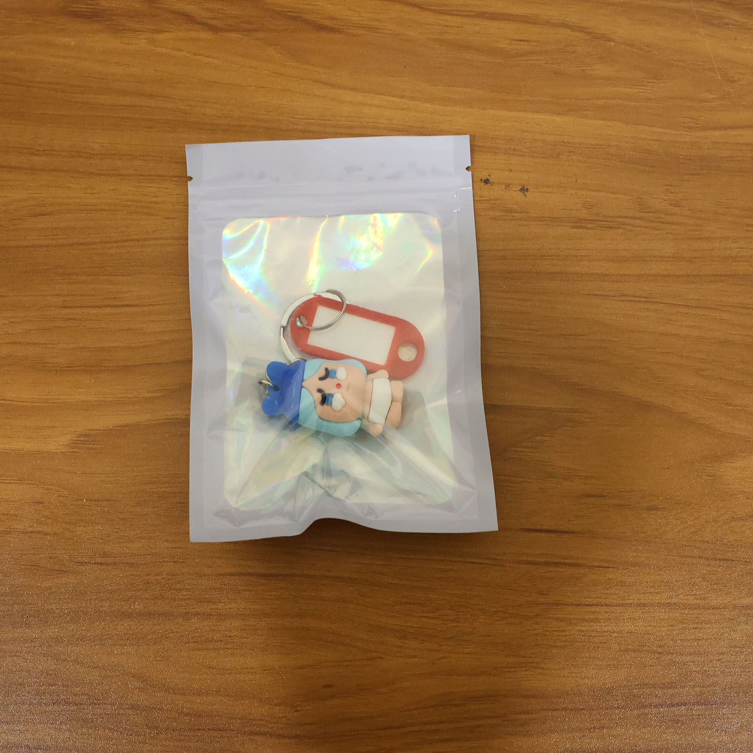 Lifestyle image of cartoon baby character keychain used on backpack zipper.