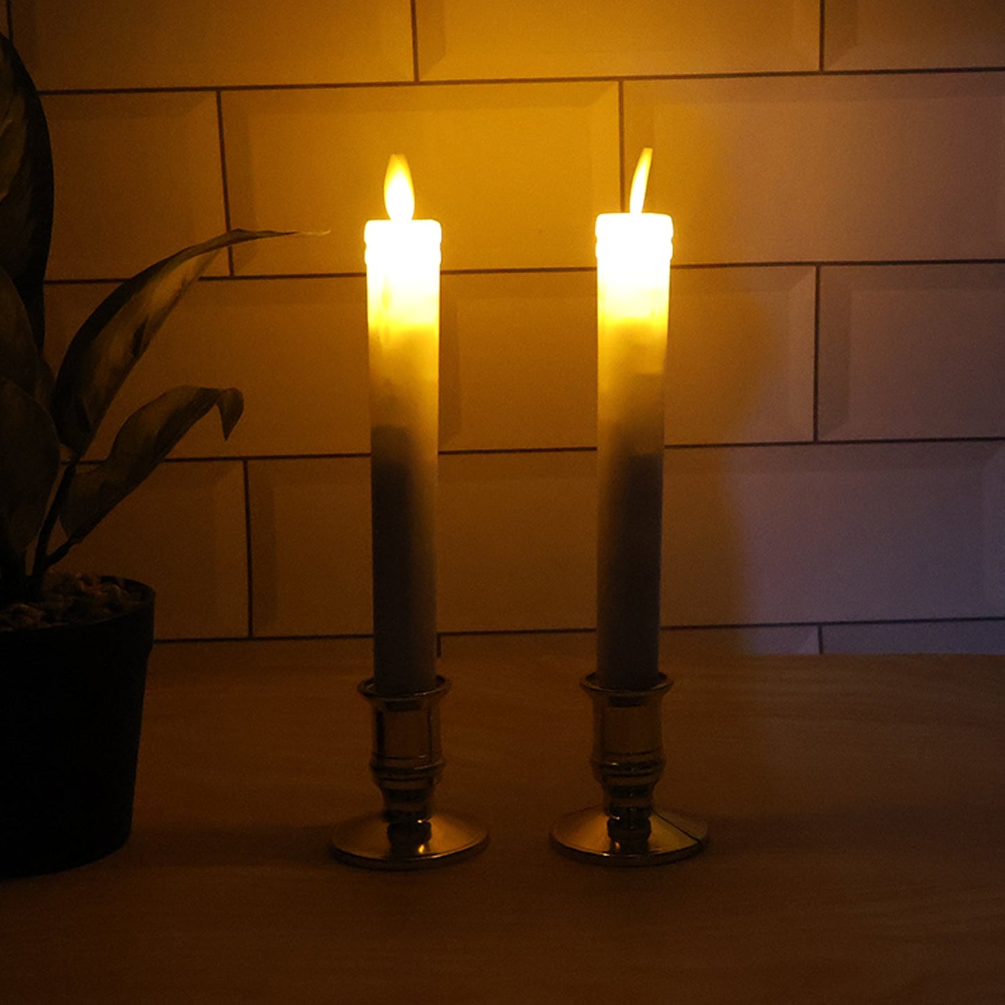Pair of battery operated flameless LED taper candles glowing warmly during festival celebration