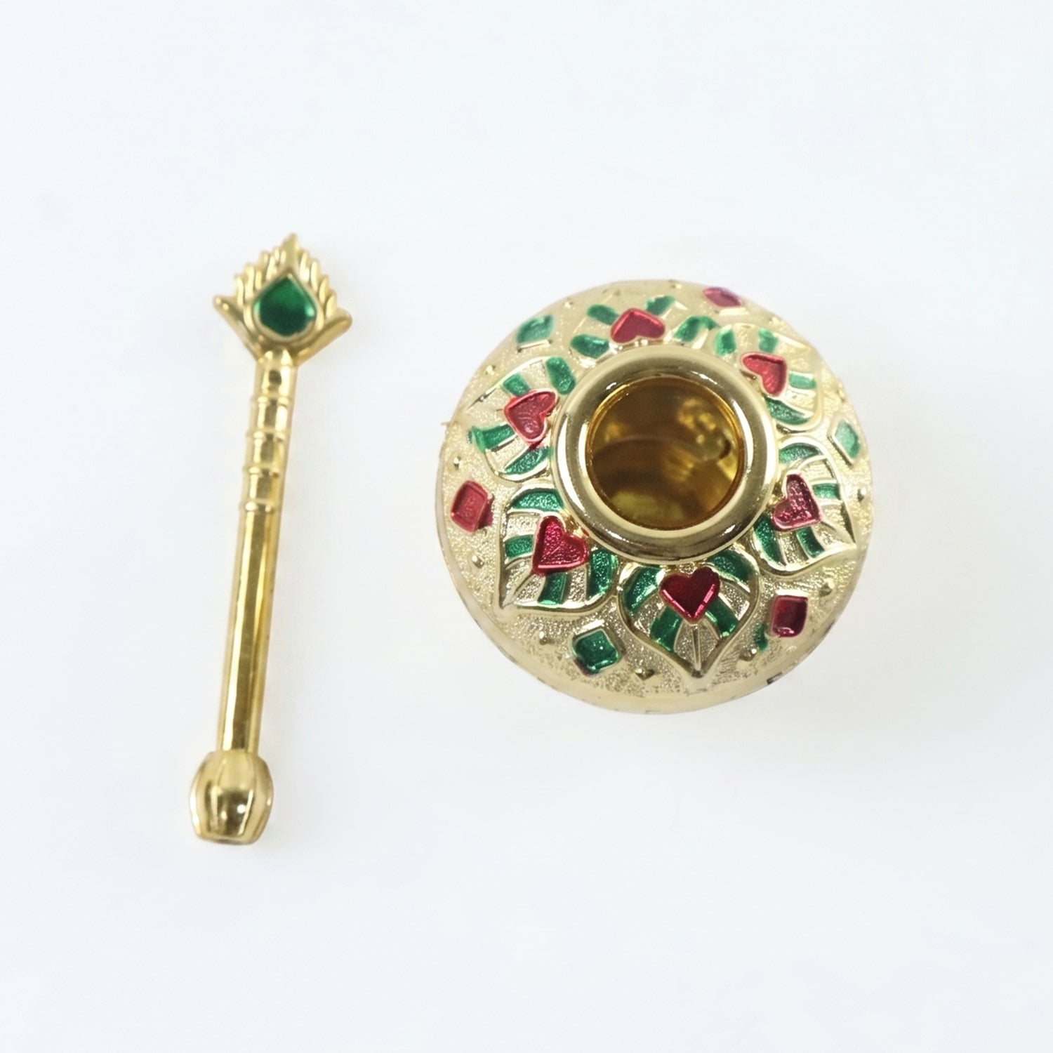 A gold decorative pot and spoon, adorned with red and green enamel, are shown on a plain white background.