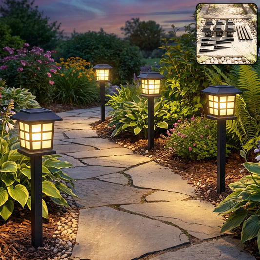 Four square black solar lanterns illuminate a winding stone pathway through a lush garden at dusk.