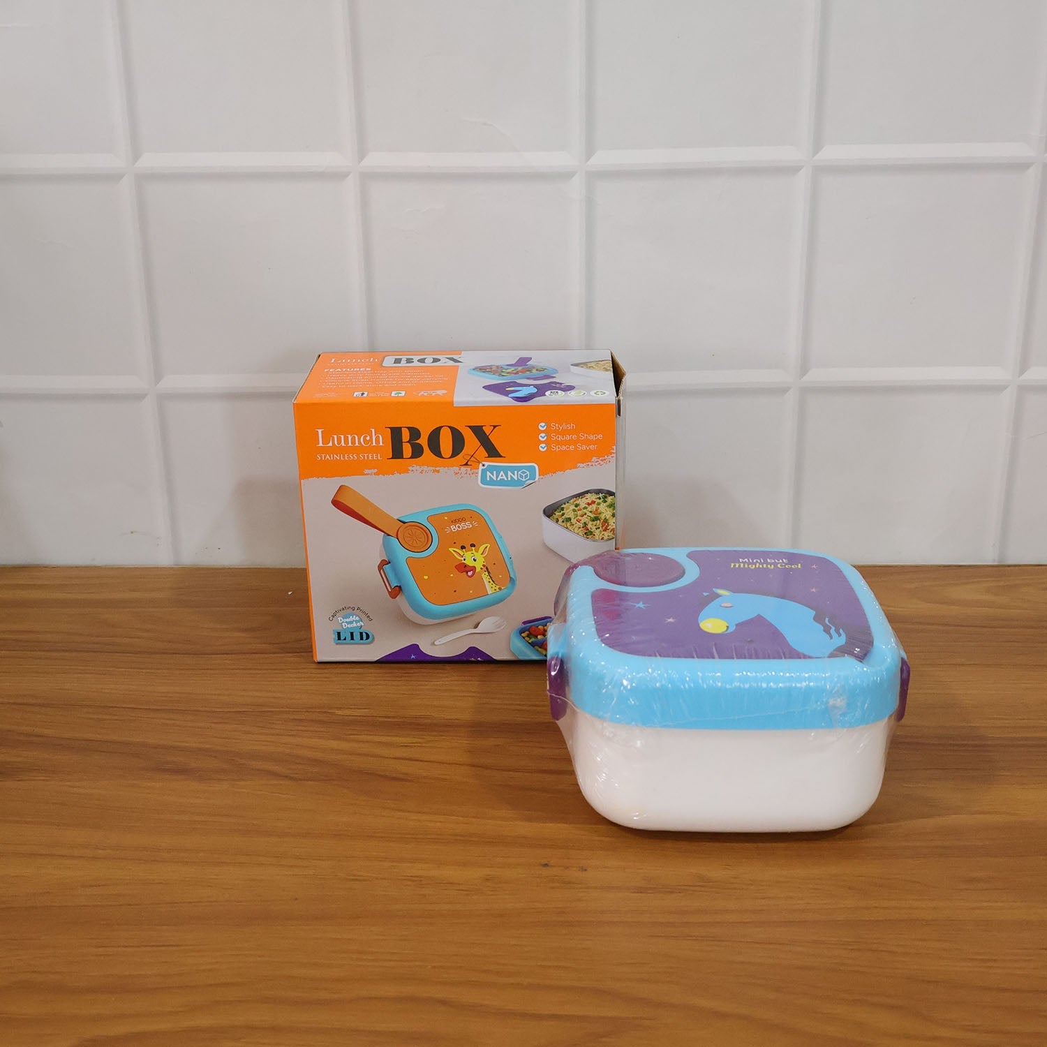 Kids lunch box on a table displaying the giraffe print and stainless tray