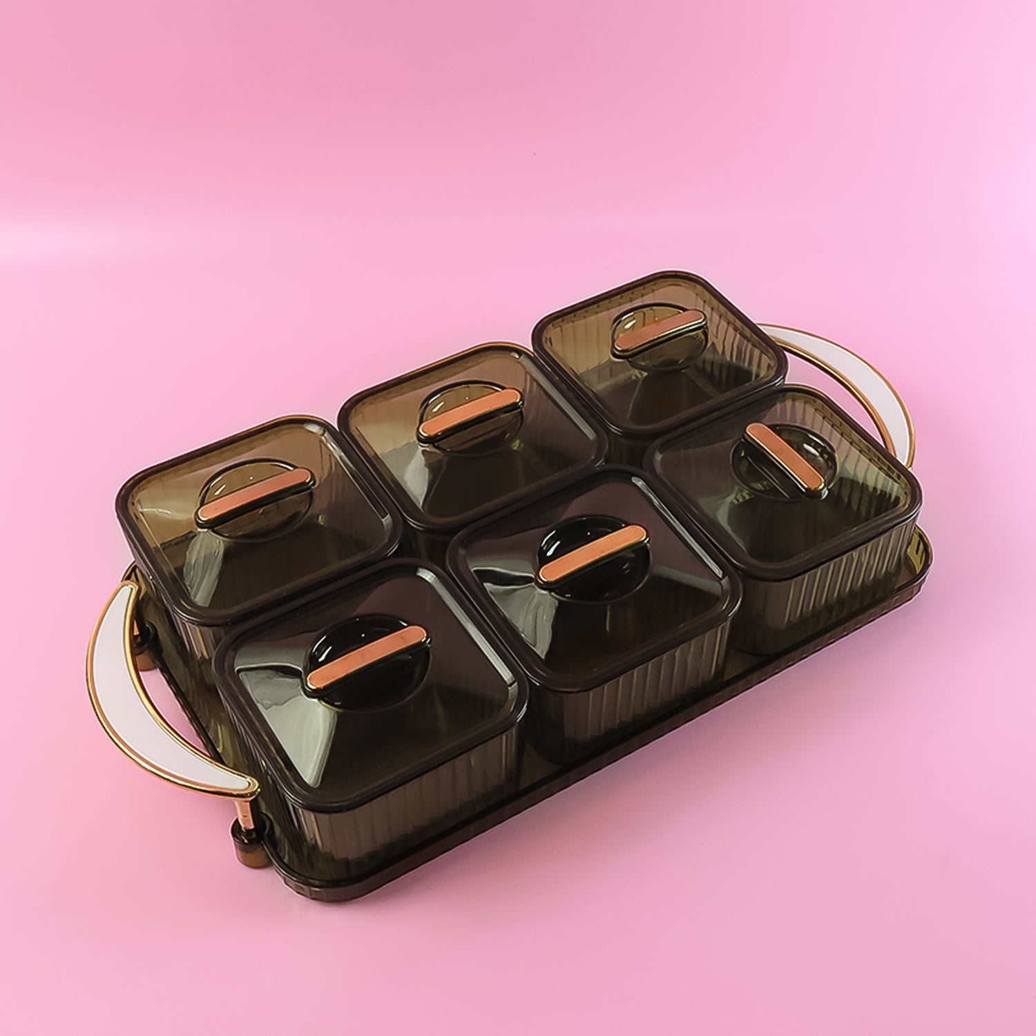 Top view of clear ribbed spice jars with lids on a golden tray