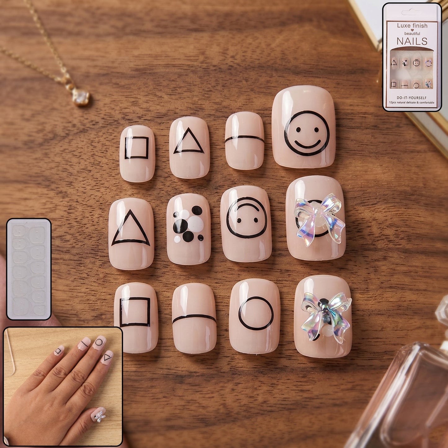 A set of 12 short, square, nude press-on nails with various black geometric shapes and two with iridescent bows.