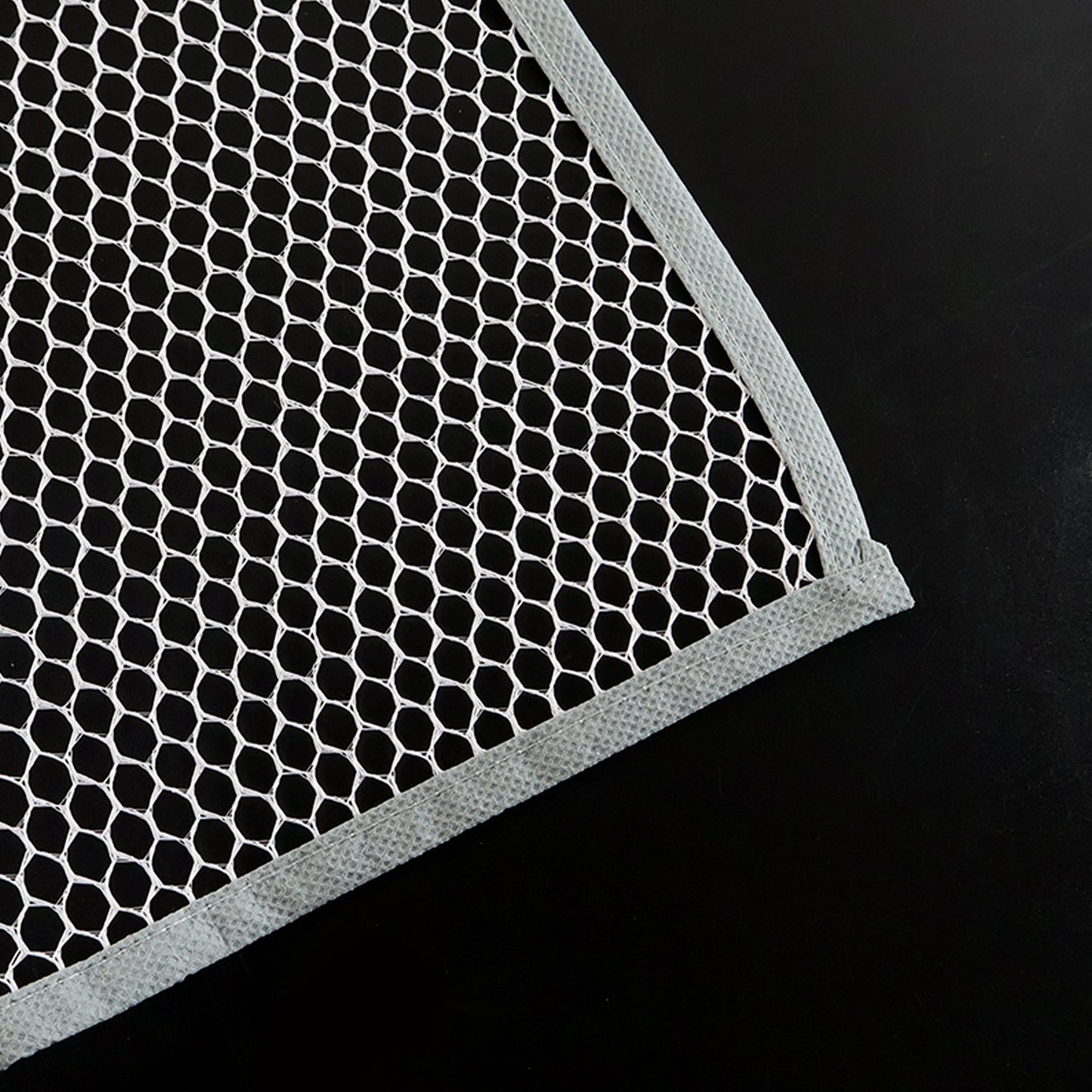 Hand holding the lightweight Large Ironing Press Net mesh protector cloth