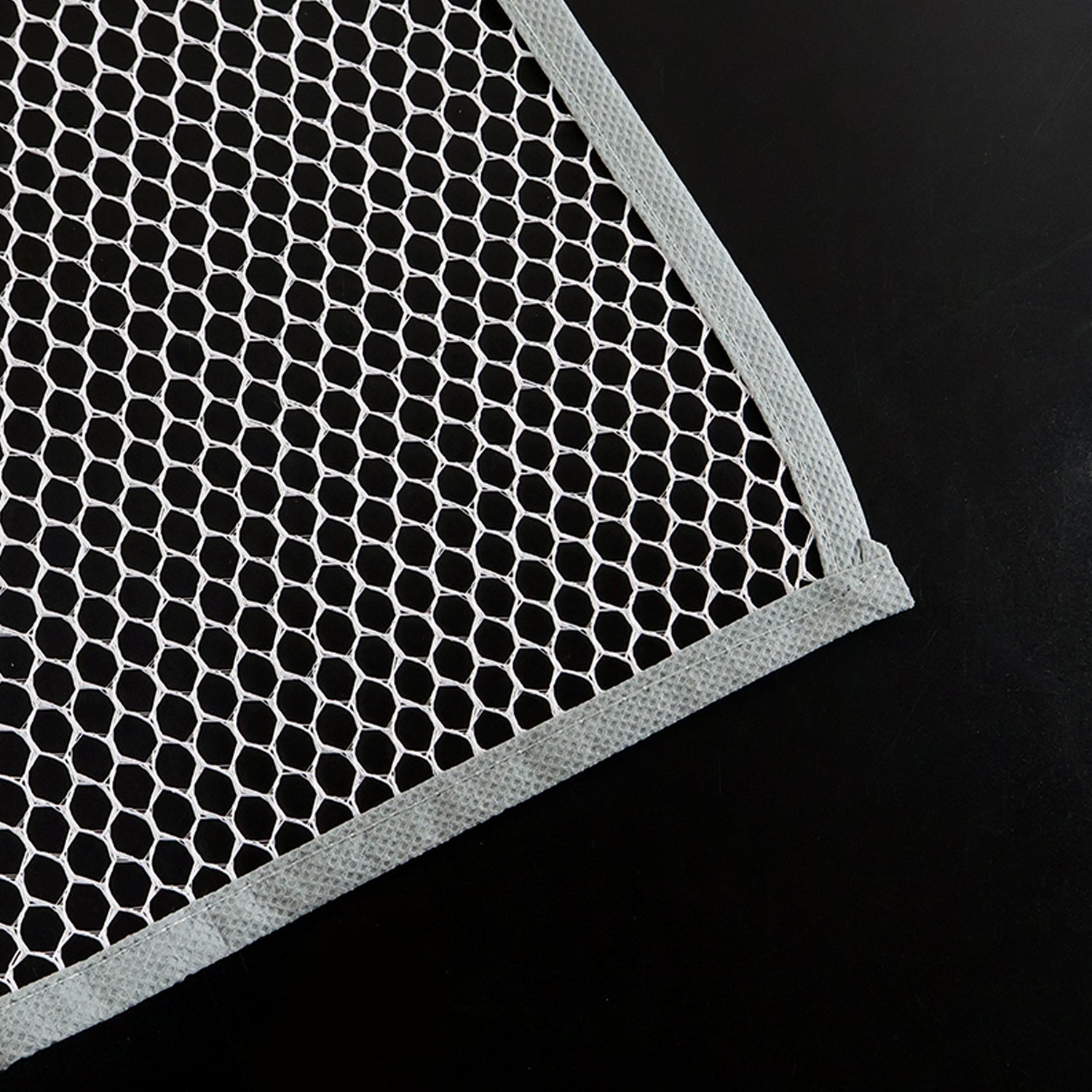 Hand holding the lightweight Large Ironing Press Net mesh protector cloth