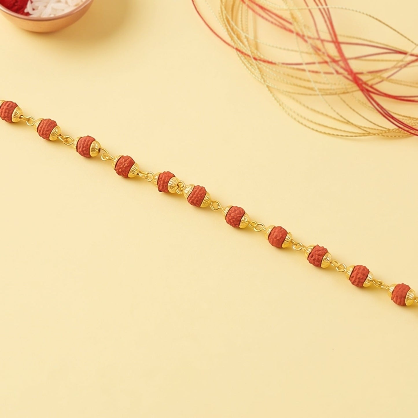 Rudraksha bead bracelet rakhi with gold plated caps on a brother's wrist.