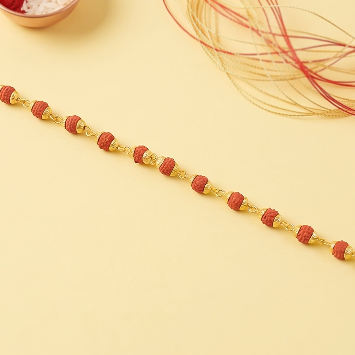 Rudraksha bead bracelet rakhi with gold plated caps on a brother's wrist.