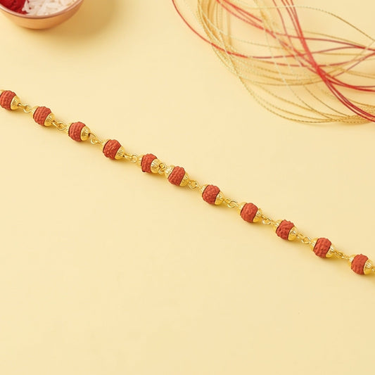 Rudraksha bead bracelet rakhi with gold plated caps on a brother's wrist.