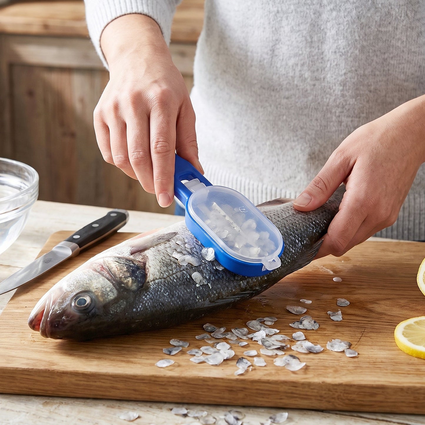The blue fish scaler with a clear lid and a silver blade is shown against a plain white background.