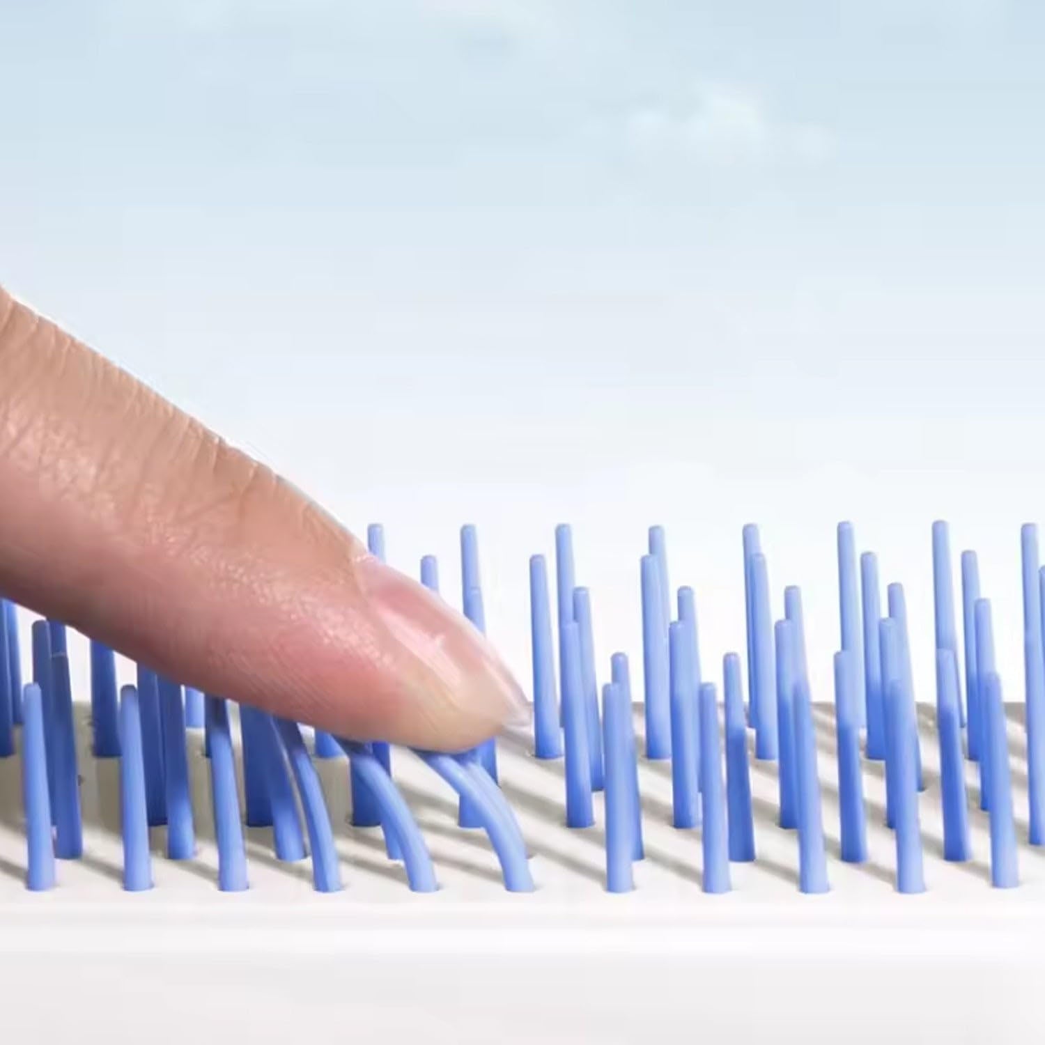 Slider retracting bristles to lift collected hair off the brush