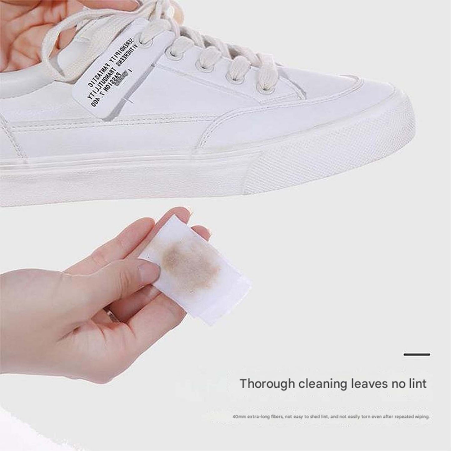 Hand cleaning brown leather shoe with a shoe cleaning wipe