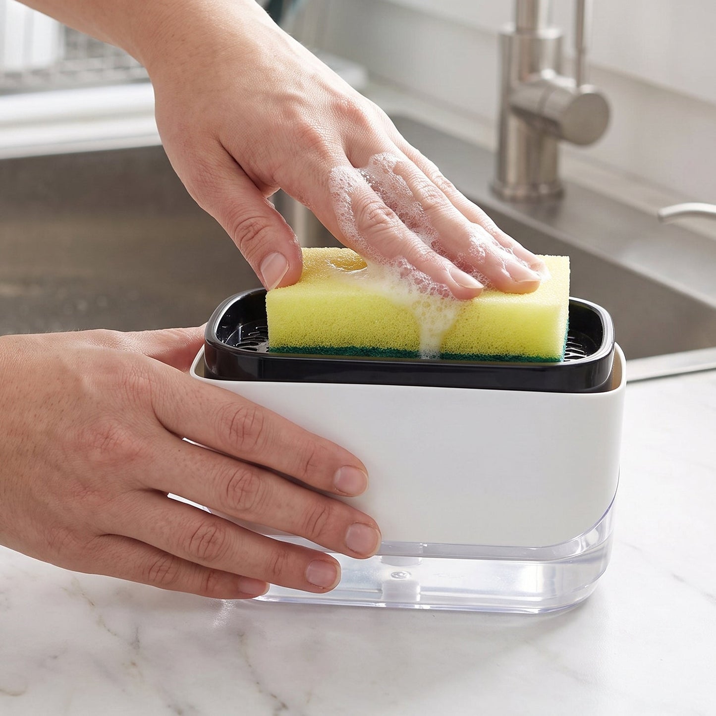 A person's hands press a yellow sponge onto a white and black soap dispenser, creating suds, next to a kitchen sink.