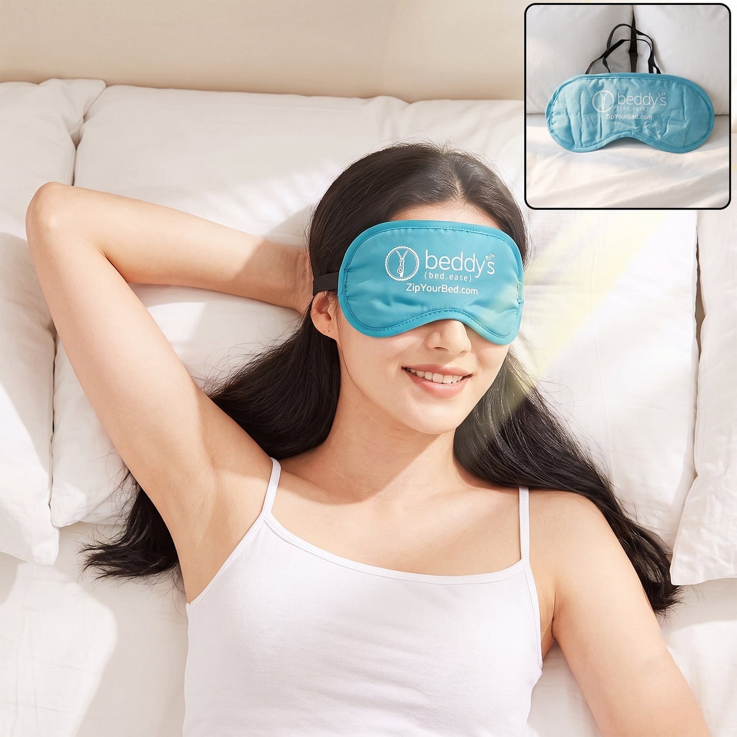 A woman with long dark hair smiles while lying on a white bed, wearing a light blue sleep mask with a white logo.