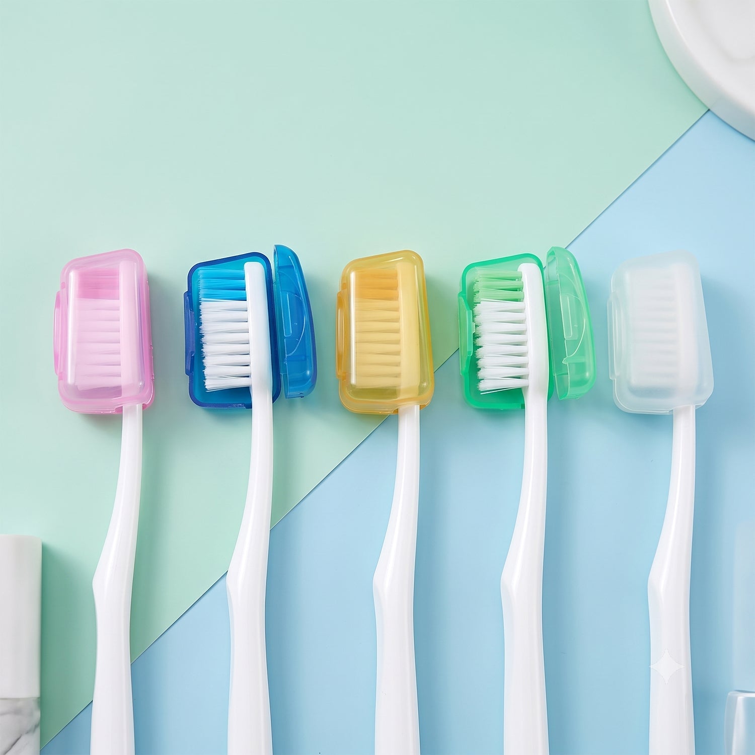 Five toothbrushes with white handles and colorful bristles have matching translucent head covers in pink, blue, yellow,
