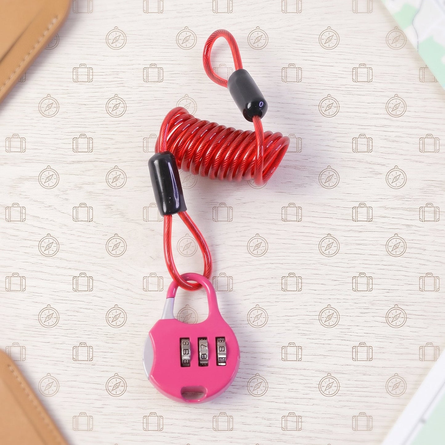 A pink combination lock with a red coiled cable is displayed on a patterned travel-themed background.