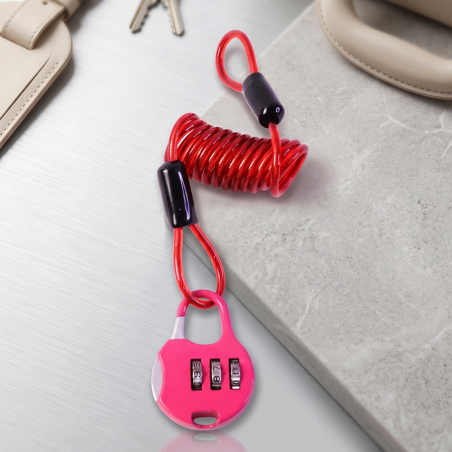 A pink combination lock with a red coiled cable is displayed on a light gray and white textured surface.
