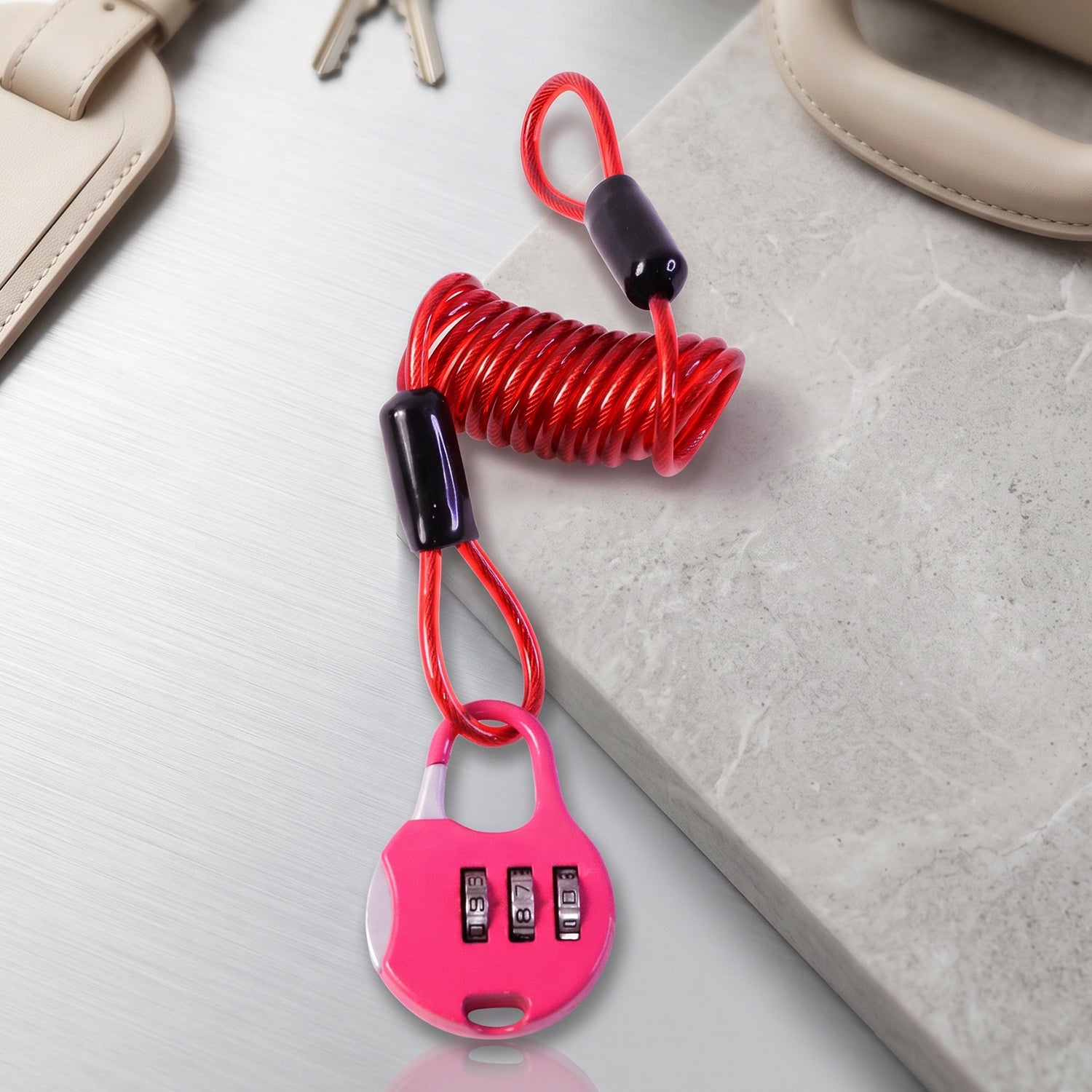 A pink combination lock with a red coiled cable is displayed on a light gray and white textured surface.