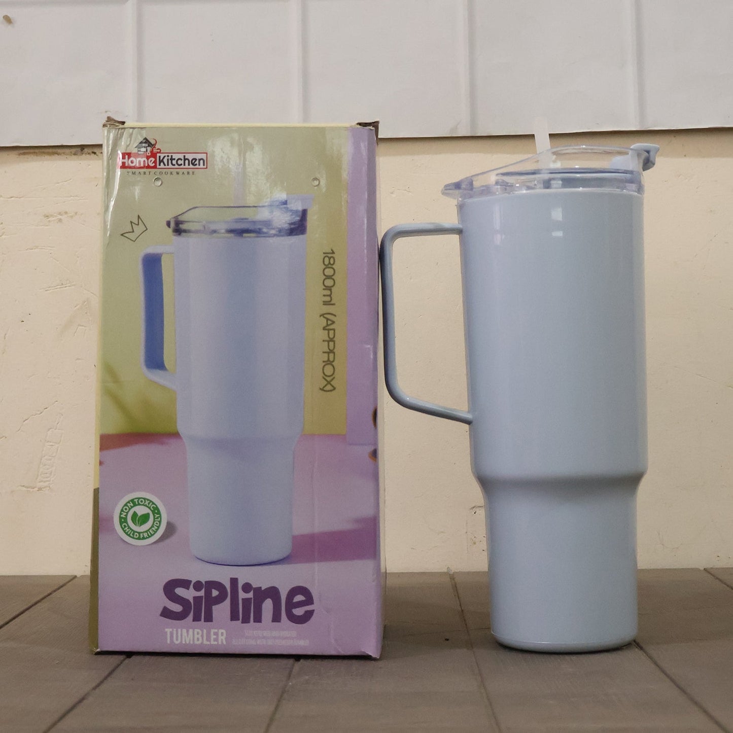 A light blue travel tumbler with a handle and straw stands next to its product box, which features a similar image.
