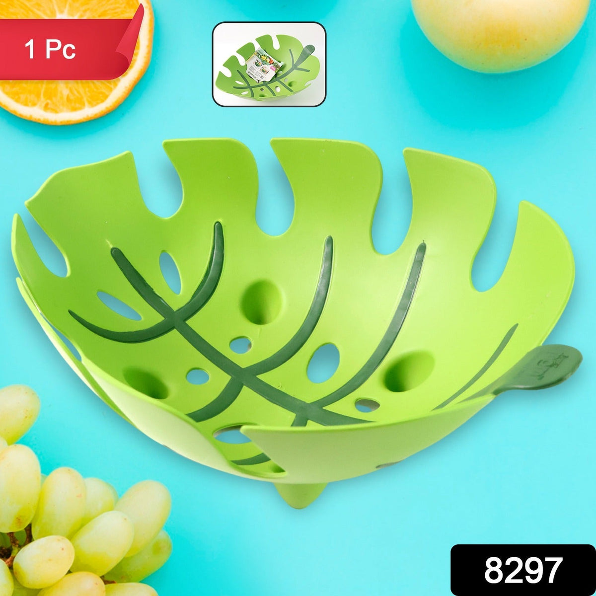 A green leaf-shaped plastic fruit basket with a small inset showing it being rinsed, on a blue background.