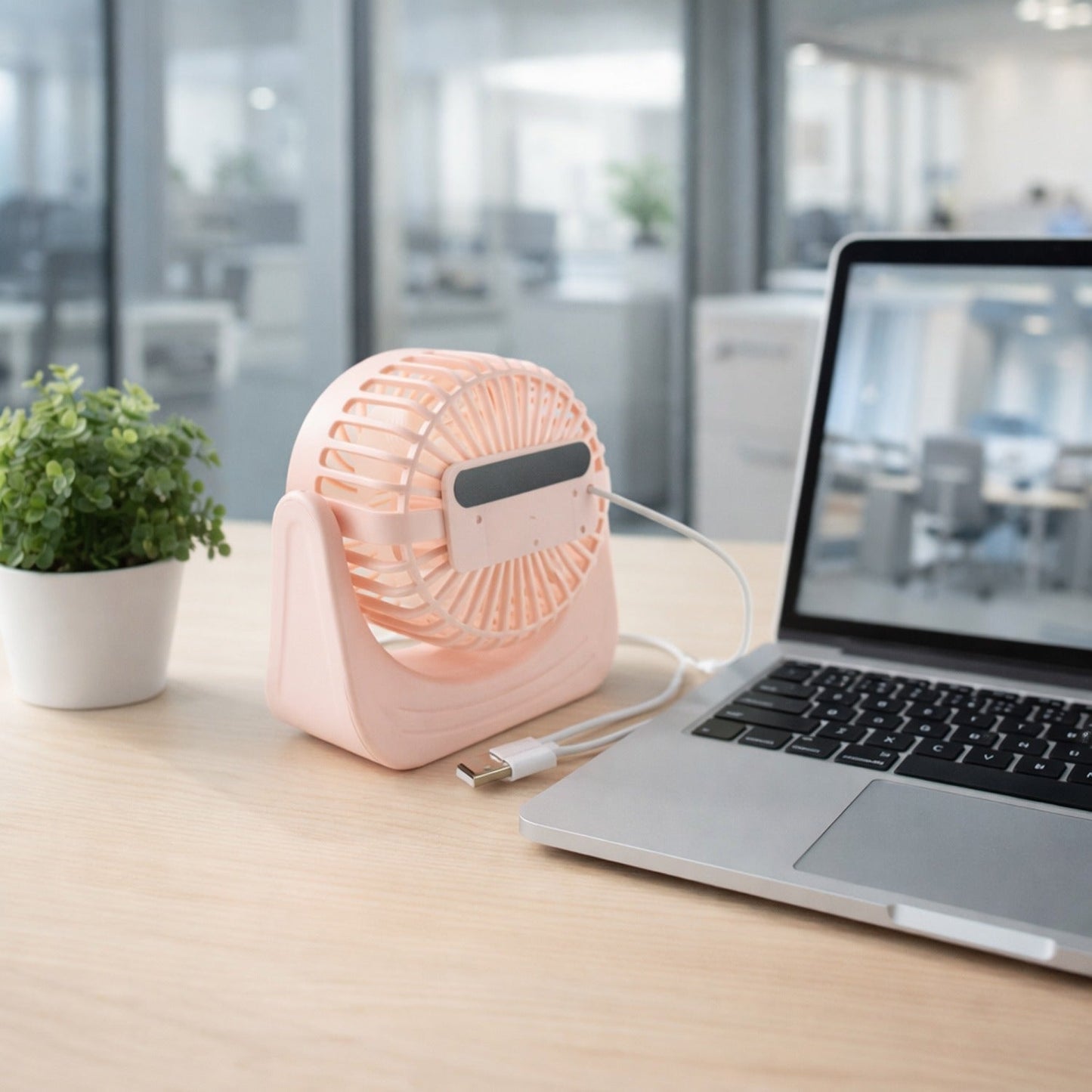Portable silent small desk fan near a laptop for personal use