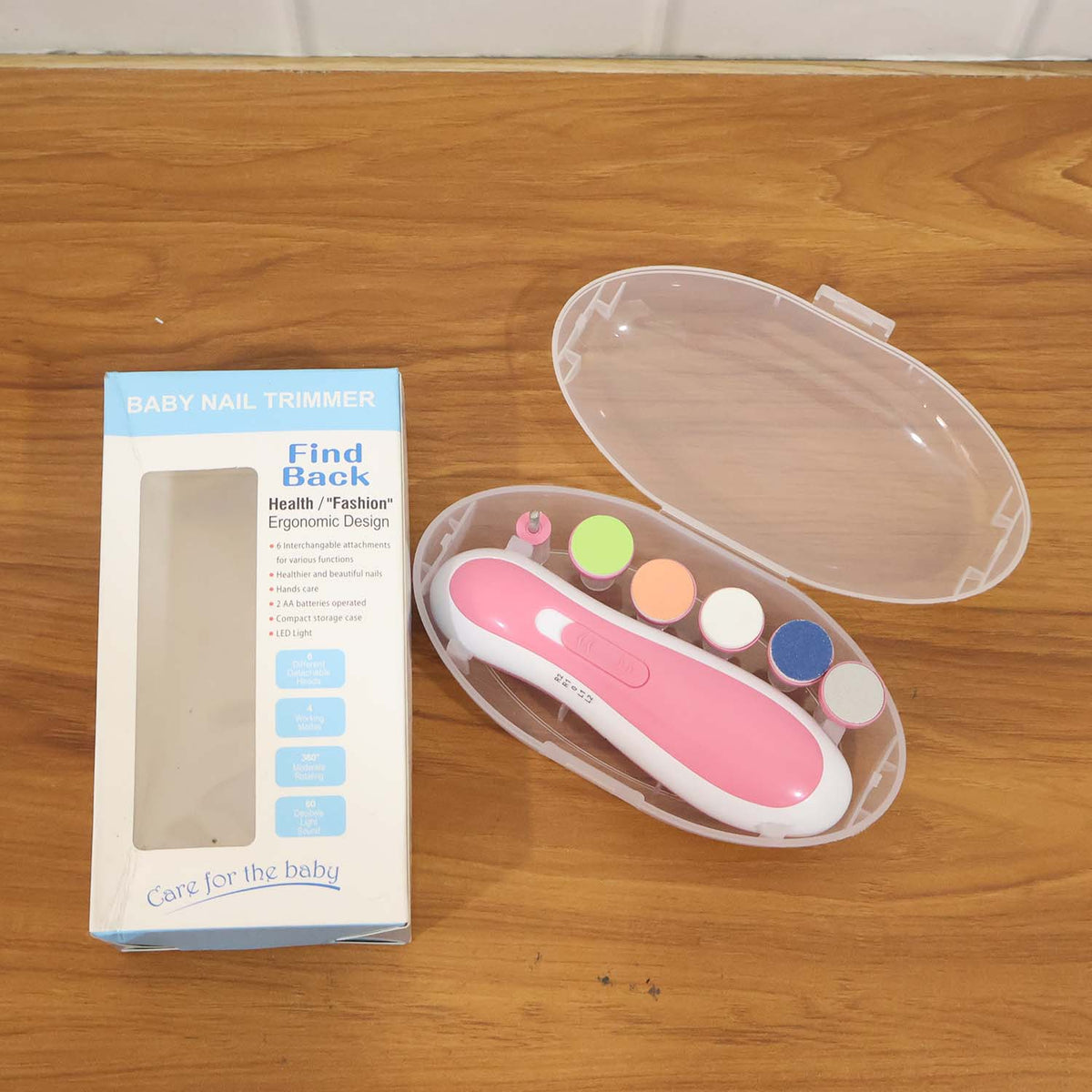 A pink electric nail trimmer kit with five grinding heads in a clear case, next to its product box.