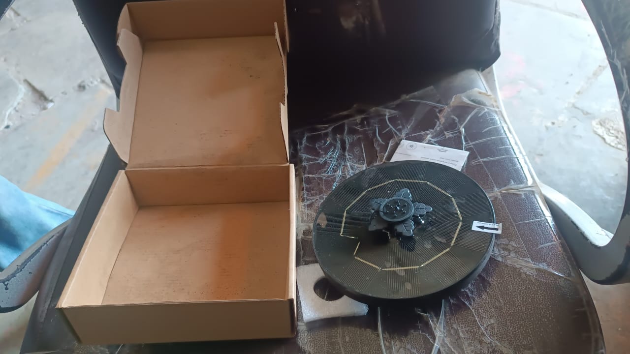 Solar floating water fountain pump positioned in garden pond for attracting wildlife