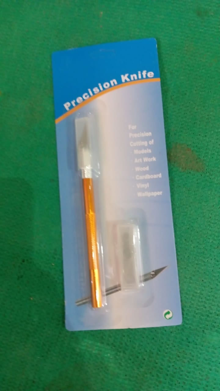 Blister packaging for a precision knife with an orange handle, shown on a green background.