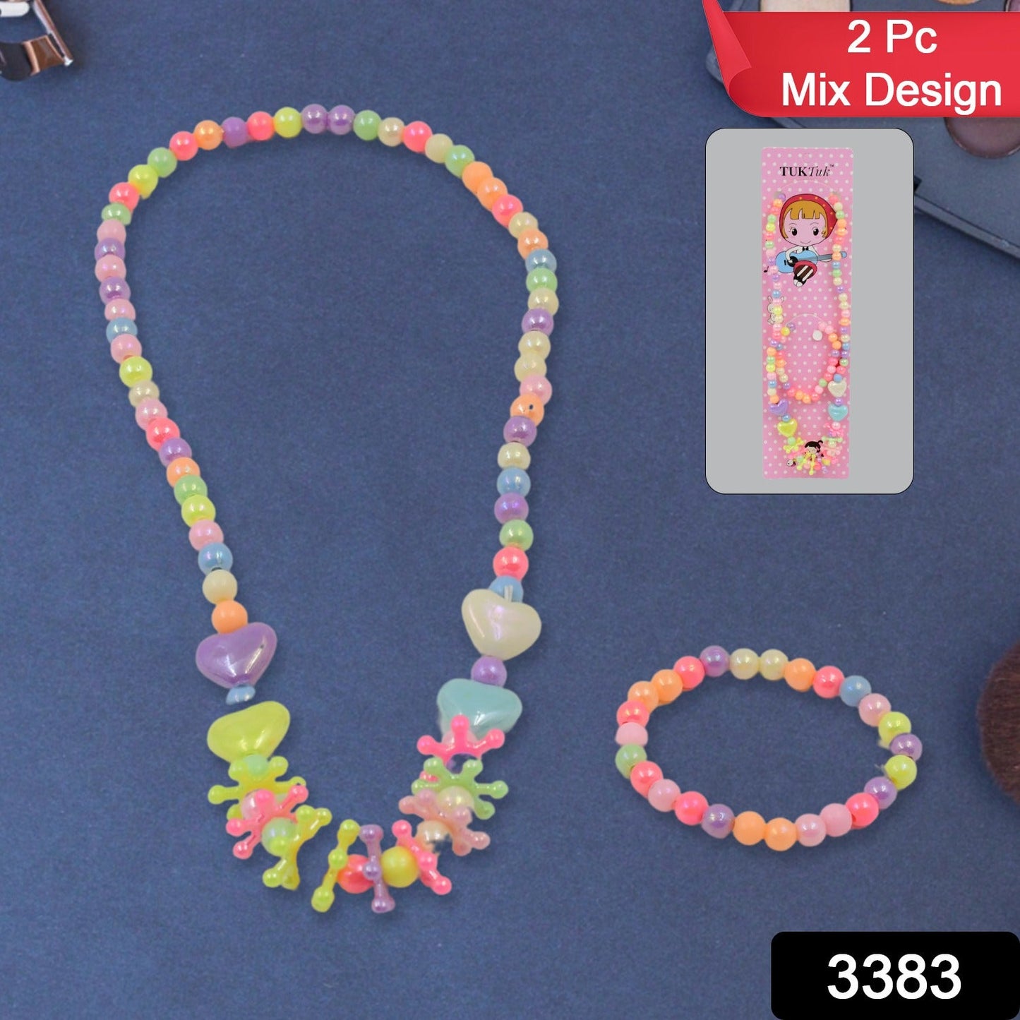 A colorful beaded necklace and bracelet set with heart and star-shaped beads is displayed on a dark blue surface next to its