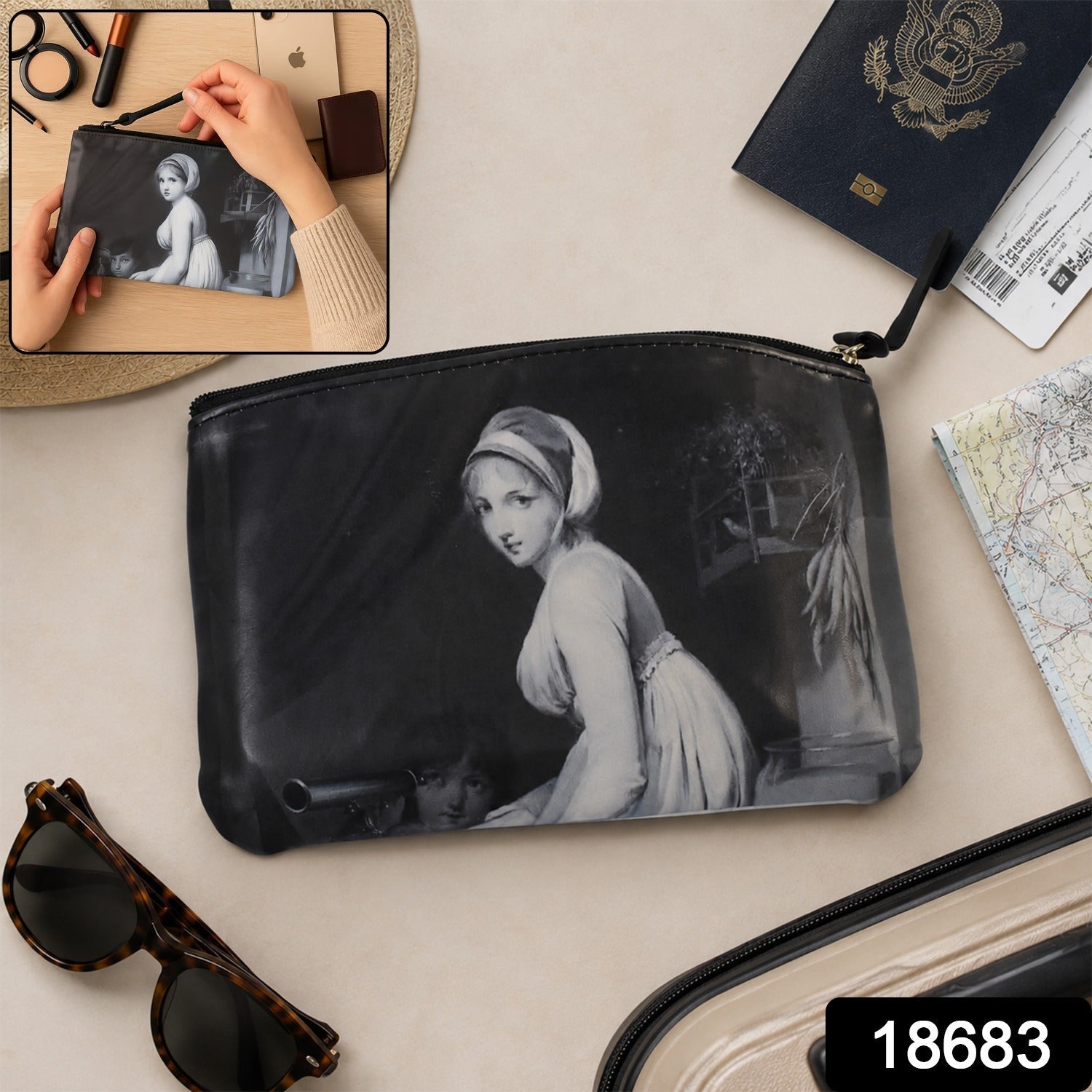 A black travel pouch with a classic painting, displayed on a white surface with makeup brushes and flowers.