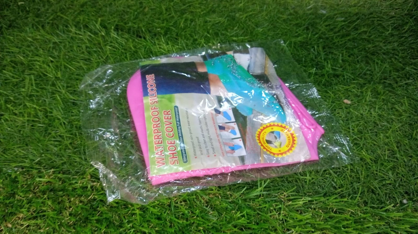 A clear plastic package containing pink silicone shoe covers, lying on green grass.