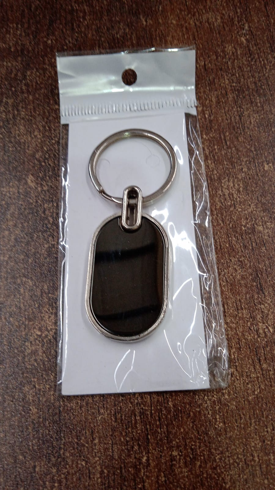 Dual tone black and silver oval keychain accessory for keys and bags