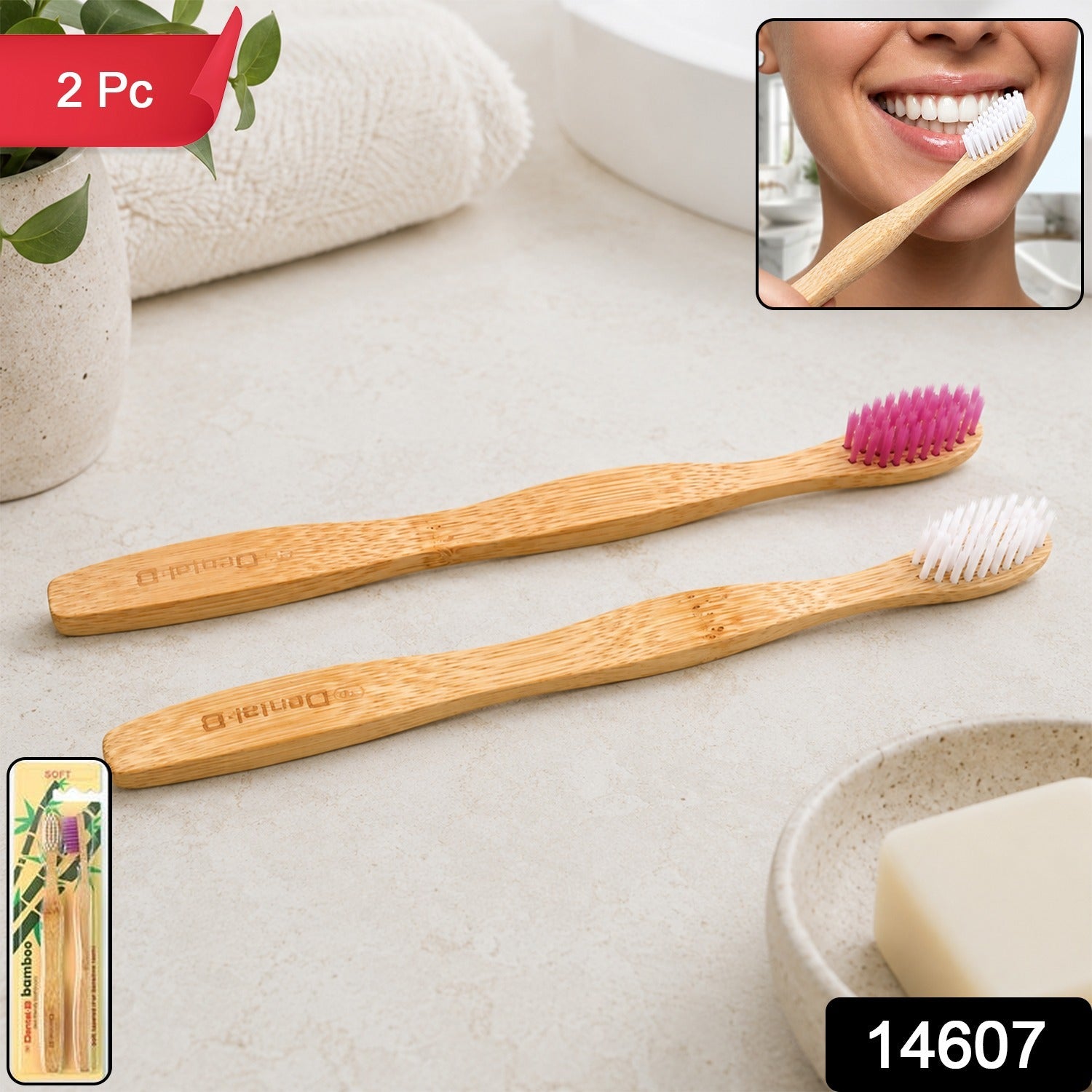 Two bamboo toothbrushes, one with pink and one with white bristles, on a bathroom counter with a person brushing their teeth