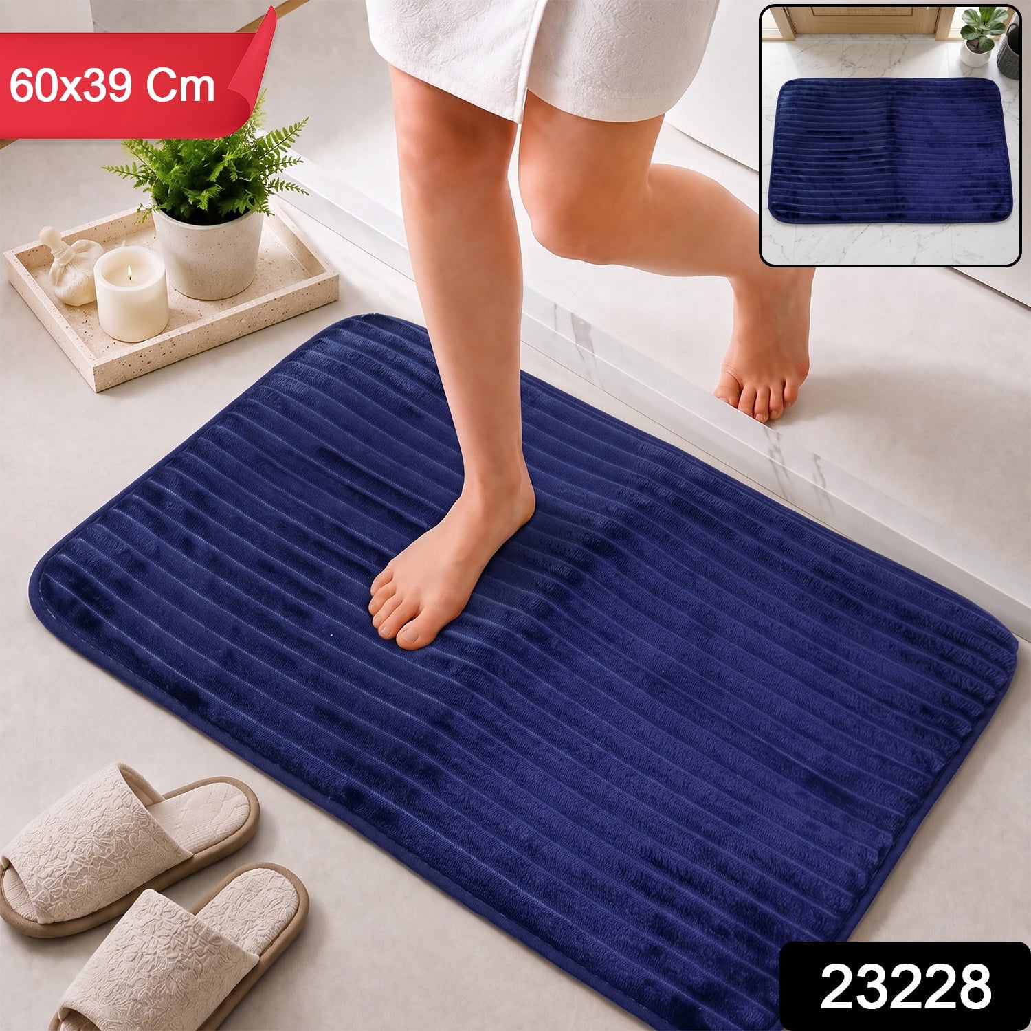 A person steps onto a navy blue ribbed memory foam bath mat, with dimensions 60x39 cm and product number 23228.