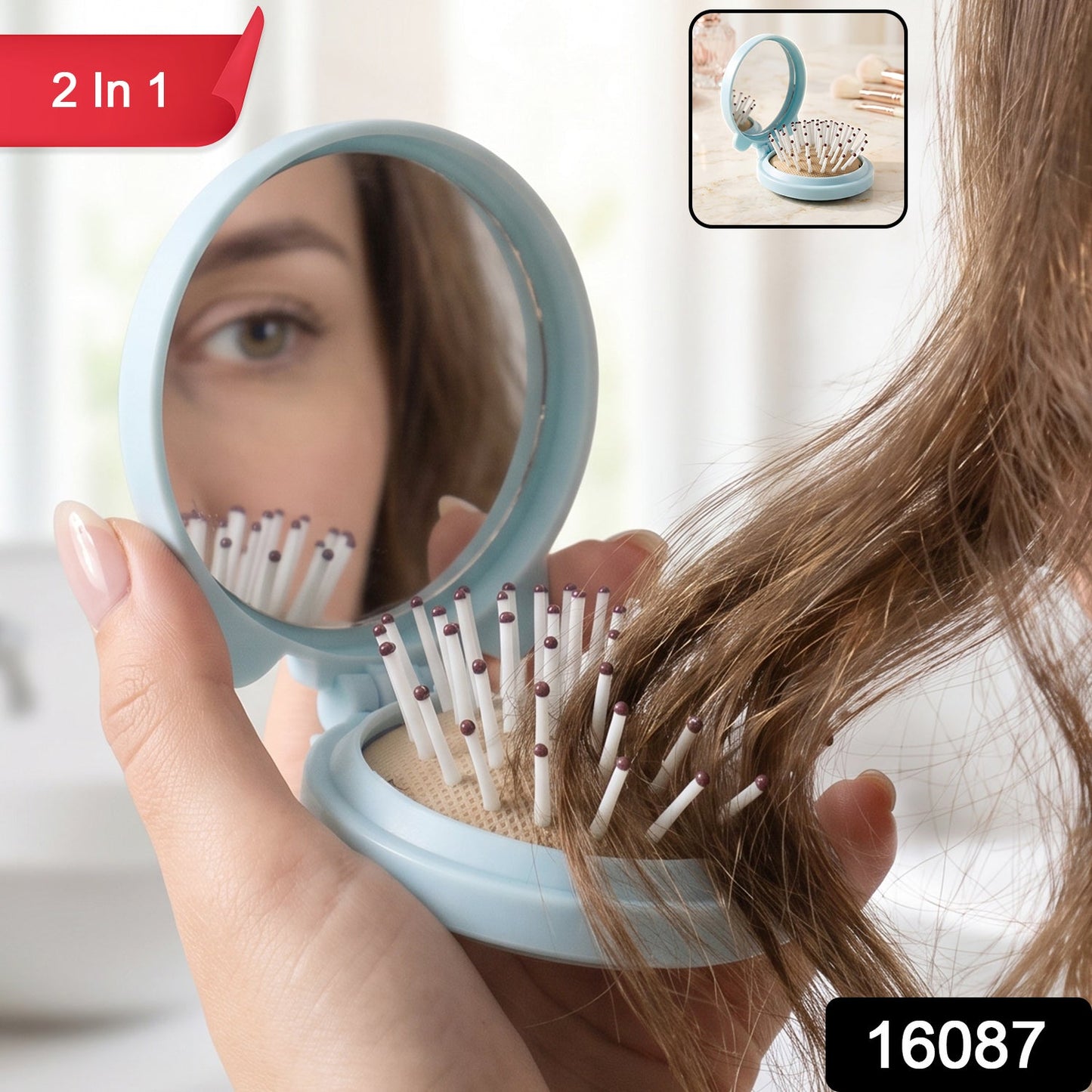 A woman's hand holds a light blue folding hairbrush with a mirror, reflecting her eye and the brush bristles, with a '2 in