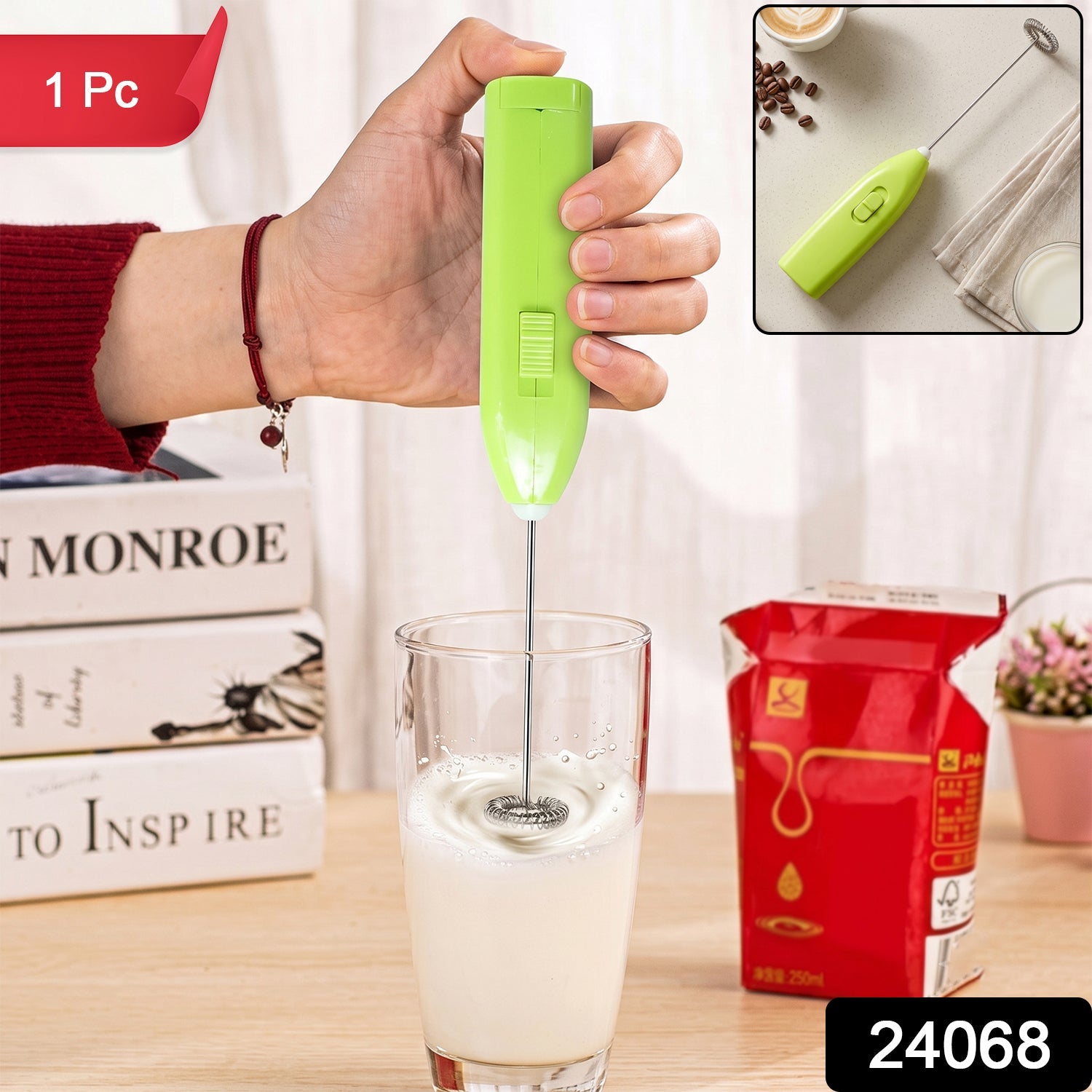 A hand holds a bright green electric frother, mixing milk in a clear glass, with books and a milk carton in the background.