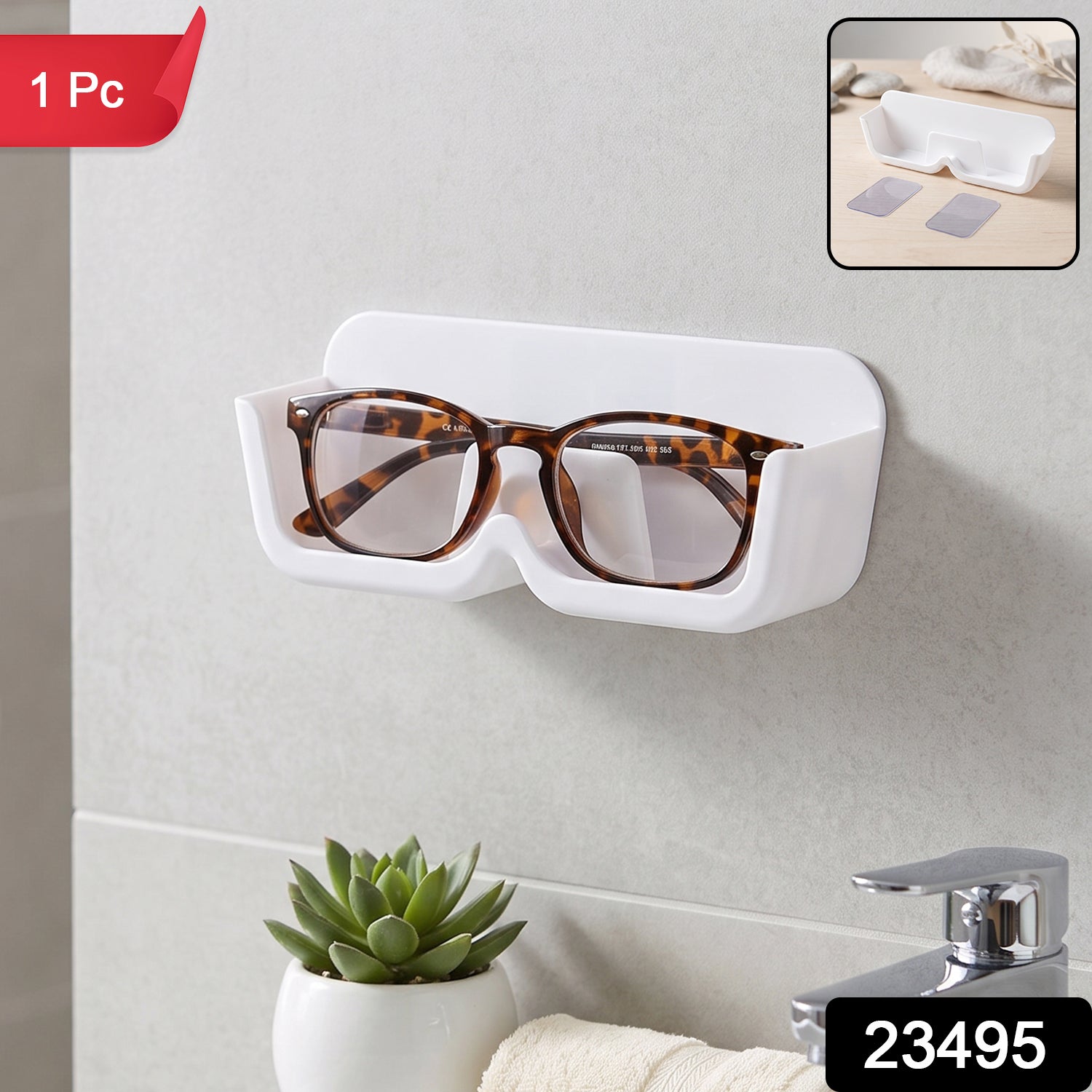 White plastic wall-mounted eyewear holder with tortoise-shell glasses, above a sink with a small green plant, with '1 Pc'