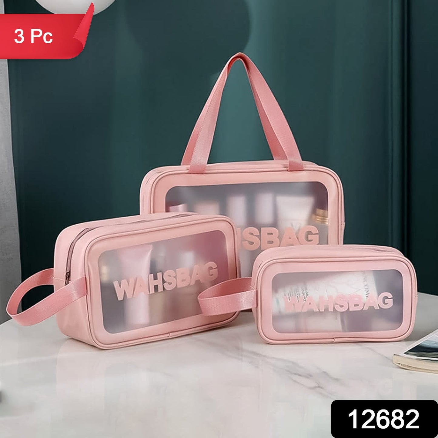 Three pink waterproof travel bags with clear panels on a white table, with a dark green wall in the background.