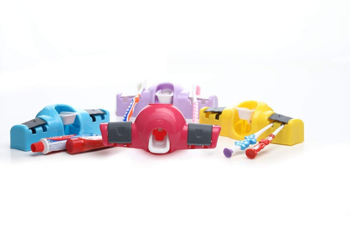 Four colorful toothpaste dispensers in blue, pink, purple, and yellow, with toothbrushes and toothpaste tubes, on a white